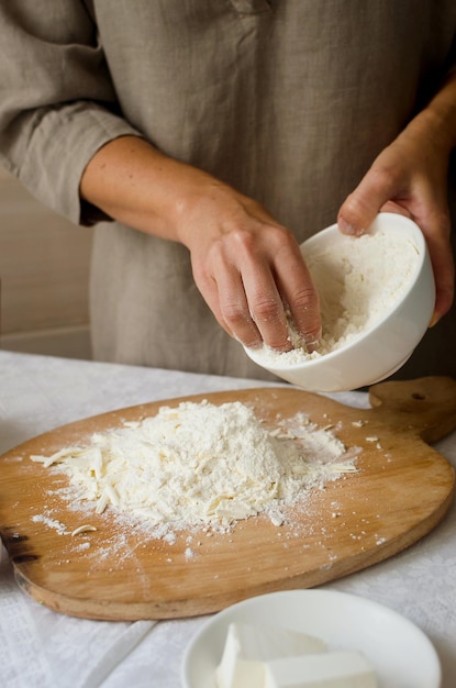 Femme faisant de la pâte pour la galette maison aux pommes et aux prunes en gros plan