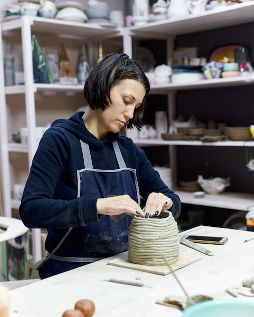 Femme faisant de la poterie en céramique sur l'atelier. Concept pour femme en freelance, affaires. Artisanat