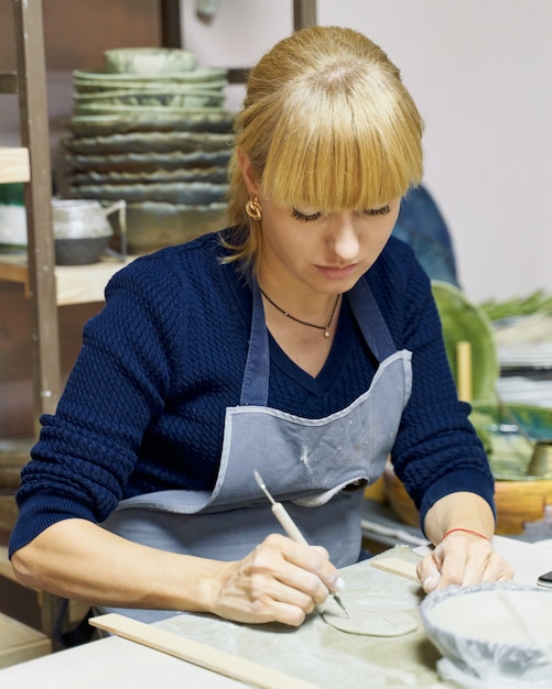 Femme faisant de la poterie en céramique.