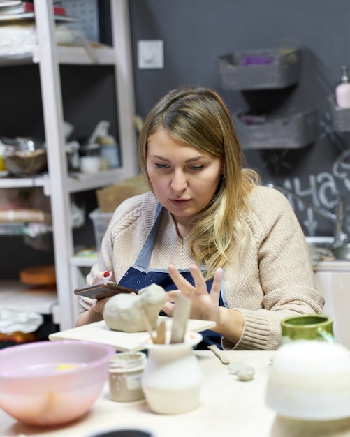 Femme faisant de la poterie en céramique.