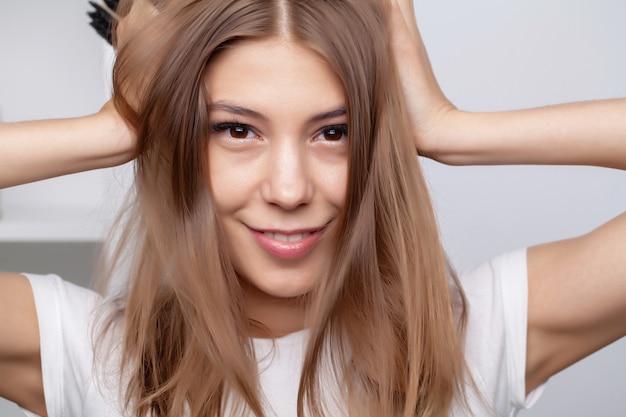 Femme faisant des procédures de soins capillaires dans la salle de bain