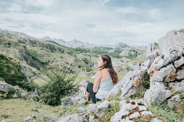 Femme faisant de la randonnée dans les montagnes et regardant la vue panoramique et les terres magiques, voyageant à pied, mode de vie sain, espace de copie