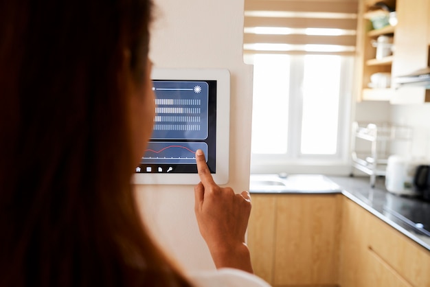 Photo femme faisant le réglage de sa maison avec application en ligne