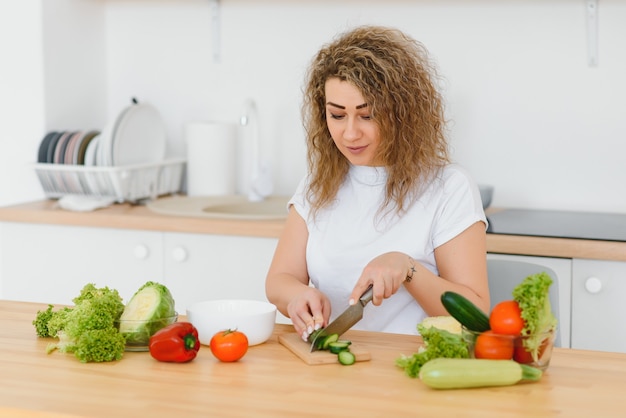 Femme faisant de la salade dans la cuisine.