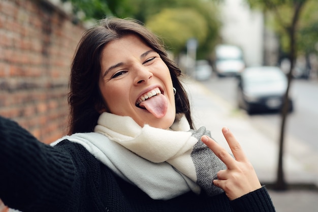 Femme faisant selfie et montrant la langue.