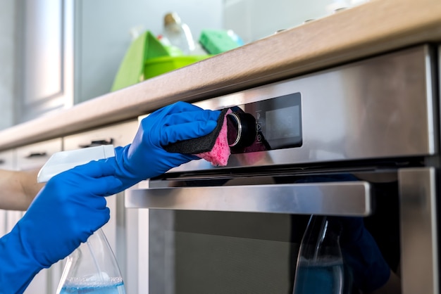 Femme faisant des tâches de nettoyage de cuisine avec des gants en caoutchouc et un chiffon. concept de nettoyage