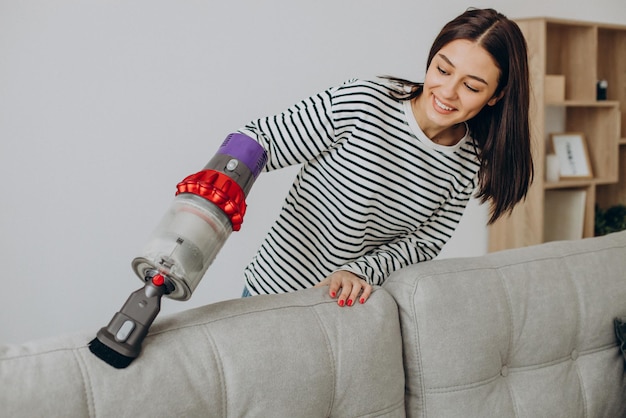 Femme faisant des travaux ménagers avec un aspirateur rechargeable