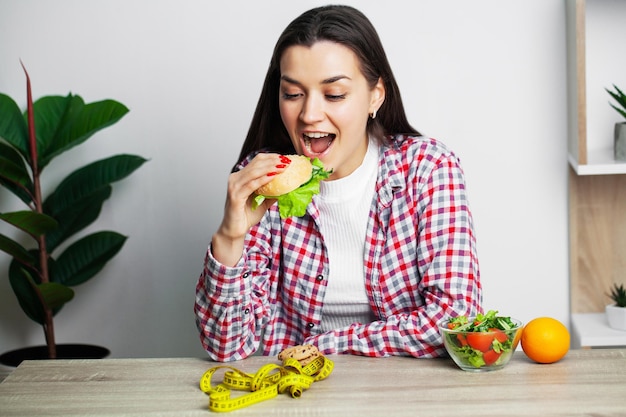 La femme fait un choix entre des aliments sains et nocifs