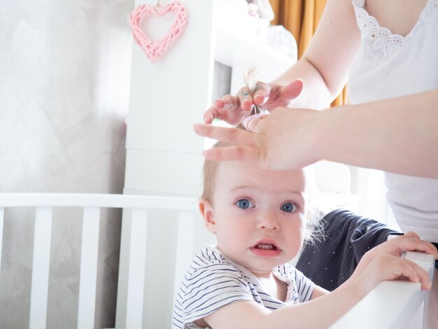 Une femme fait une coiffure pour sa petite fille en lui attachant les cheveux