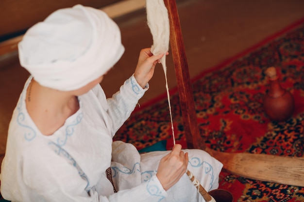 La femme fait du fil, du fil et du tissu