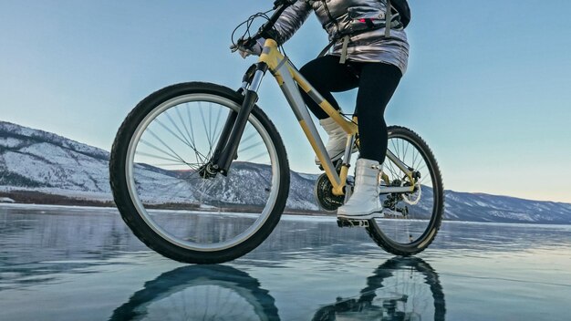 La femme fait du vélo sur la glace Les pneus de vélo sont couverts wi