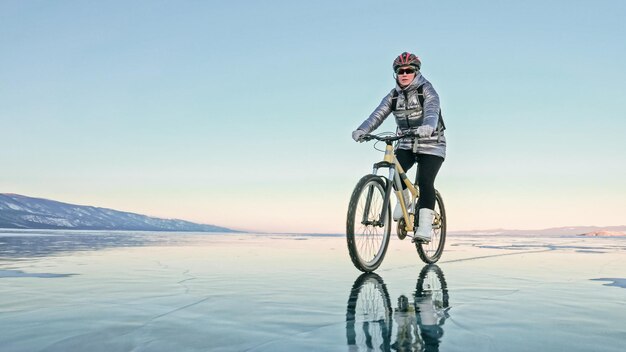 Photo la femme fait du vélo sur la glace les pneus de vélo sont couverts wi