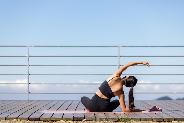 Une femme fait du yoga sur la montagne.