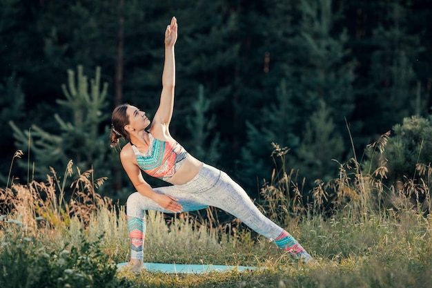 Une femme fait du yoga en plein air Le concept du sport