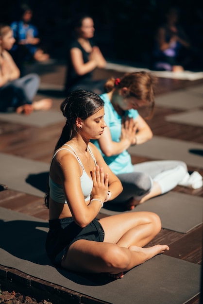 Une femme fait du yoga avec son groupe en plein air