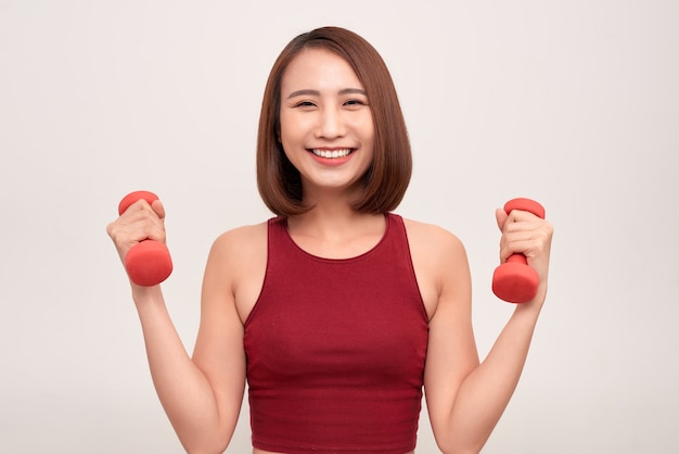 La femme fait de l'exercice avec des haltères