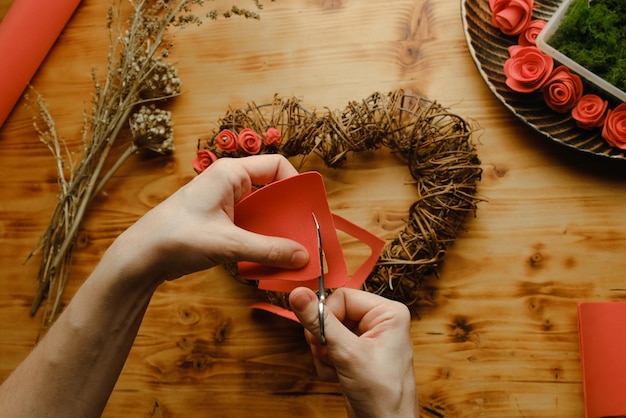 Une femme fait des fleurs de bricolage pour une couronne florale