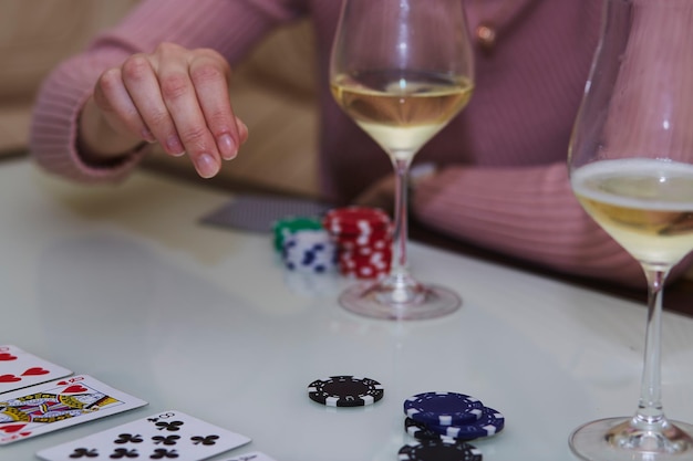 Femme fait un geste dans un jeu de cartes de jetons de poker verres de champagne sur la table avec réflexion Photographie de style de vie