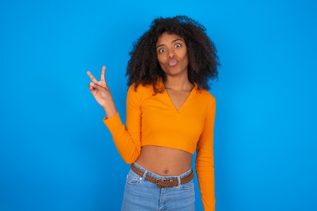 femme fait un geste de paix garde les lèvres pliées montre v signe concept de langage corporel