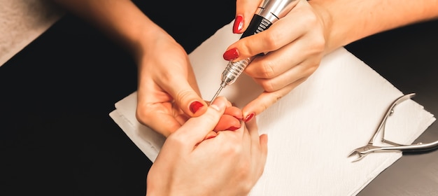 La femme fait une manucure. Procédures de salon à la maison. Belles mains et ongles.