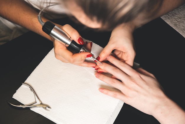 Femme fait une manucure Procédures de salon à la maison Belles mains et ongles