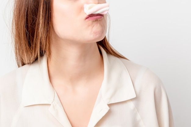 Femme fait une moustache de guimauve.