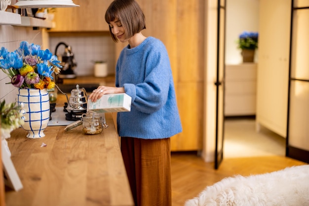 Une femme fait un petit-déjeuner avec son chien dans la cuisine