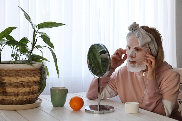 Une femme fait des procédures cosmétiques devant un miroir