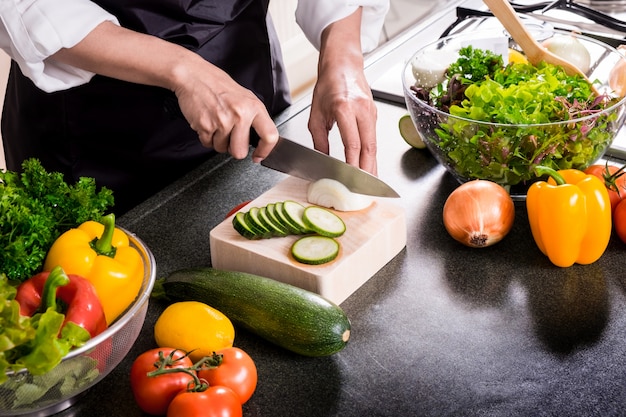 Femme fait une salade de légumes frais