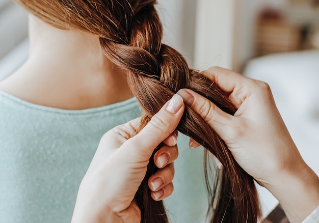 Femme fait une tresse à son amie