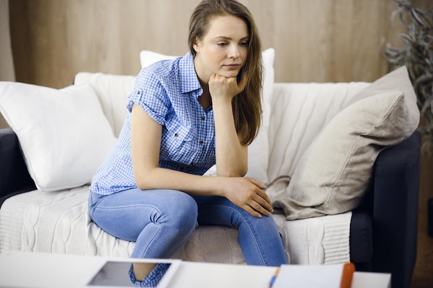 Photo une femme fatiguée, contrariée, inquiète de la fatigue du travail domestique et de l'auto-isolement en quarantaine pour covid-19 coronavirus. santé mentale, anxiété, jeune femme déprimée.