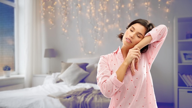 Une femme fatiguée et endormie en pyjama fait une sieste dans la chambre.