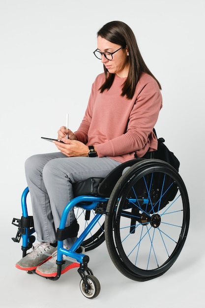 Femme en fauteuil roulant à l'aide d'une tablette numérique