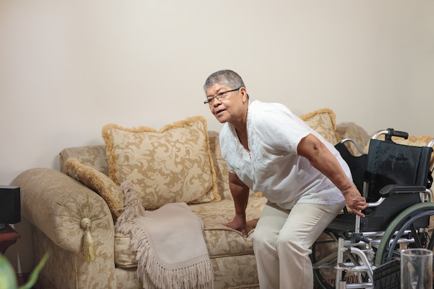 Femme en fauteuil roulant assise sur le canapé