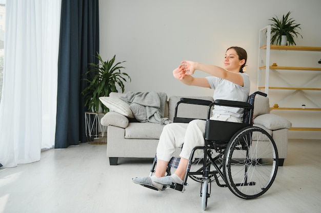 Femme en fauteuil roulant travaillant dans le salon