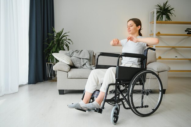 Femme en fauteuil roulant travaillant dans le salon