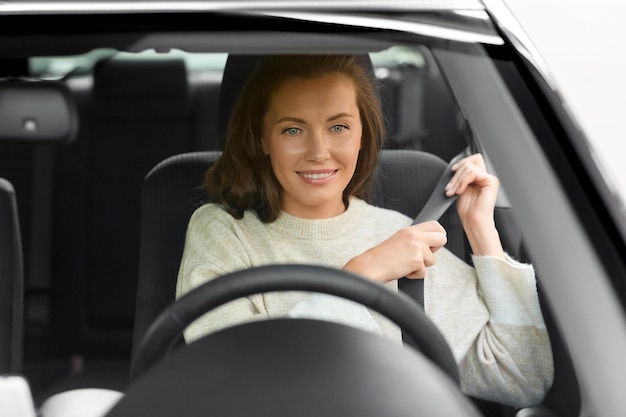 femme ou femme conducteur de voiture attachant la ceinture de sécurité