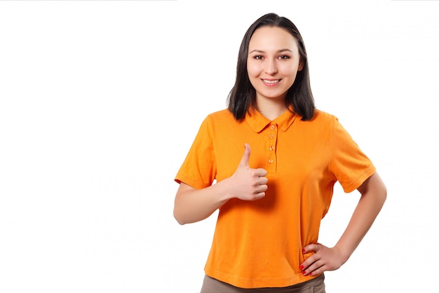 Une femme femme dans un polo brillant montre un geste du pouce levé et sourit