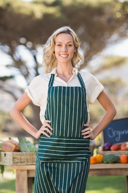 Femme fermière souriante avec les mains sur les hanches