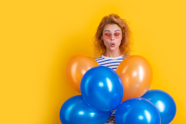 Femme de fête avec ballon à lunettes de soleil femme surprise tenir des ballons de fête en studio