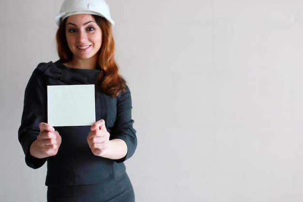 femme avec une feuille de papier vierge à la main sur un chantier de construction