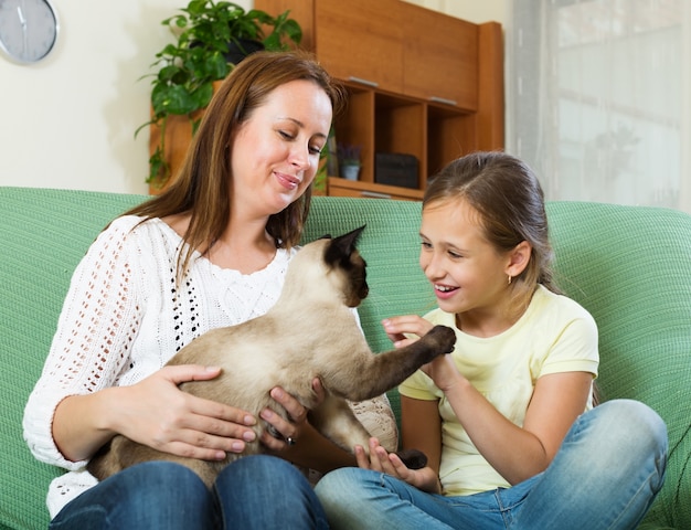 femme et fille assise avec chat