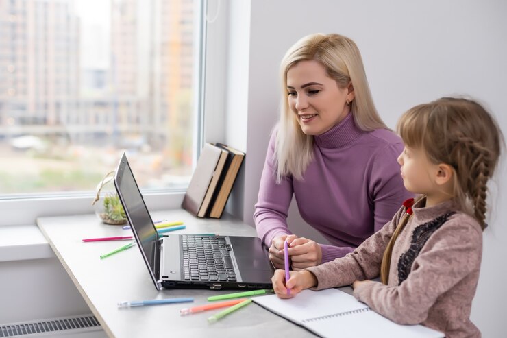 Femme avec une fille à faire ses devoirs sur un ordinateur portable