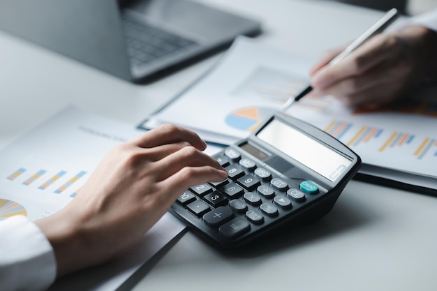 Une femme financière examine les documents financiers de l'entreprise résumé des états financiers mensuels du service financier Le concept de gestion des finances de l'entreprise pour l'exactitude et la croissance