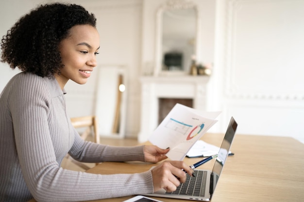 Une femme financière travaille avec des documents sur le lieu de travail d'une société financière au bureau utilise une tablette et Internet