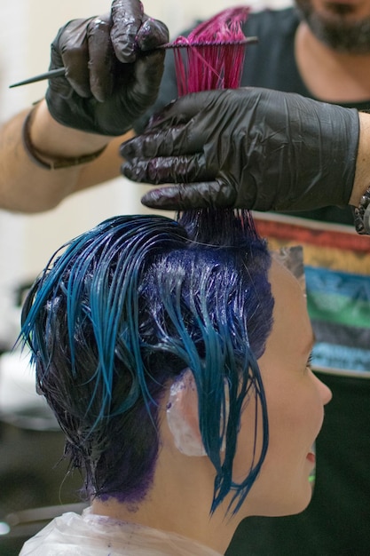 Une femme a fini de se colorer la tête en bleu chez le coiffeur Changer l'image d'une femme