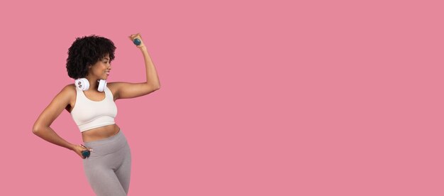 Photo une femme de fitness noire fléchissant ses muscles avec un espace libre avec des haltères