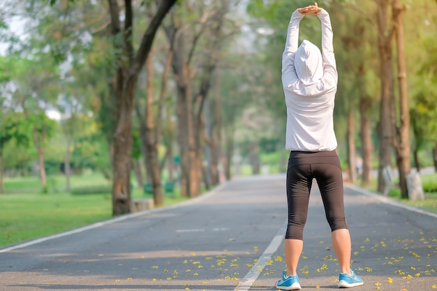 Femme de fitness streching dans le parc