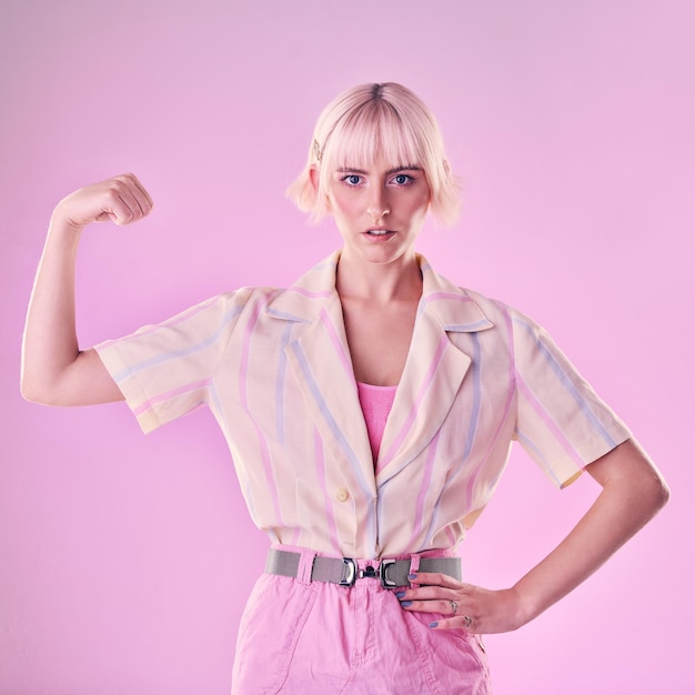 Femme fléchissant le muscle du bras en portrait avec puissance et femme forte et combat isolé sur fond rose Autonomisation de la liberté et force avec défi de confiance avec champion et gagnant