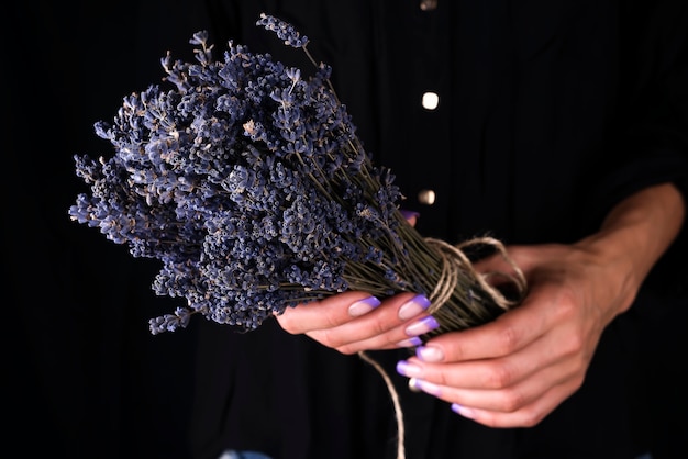 Femme fleuriste attachant un bouquet frais à la lavande